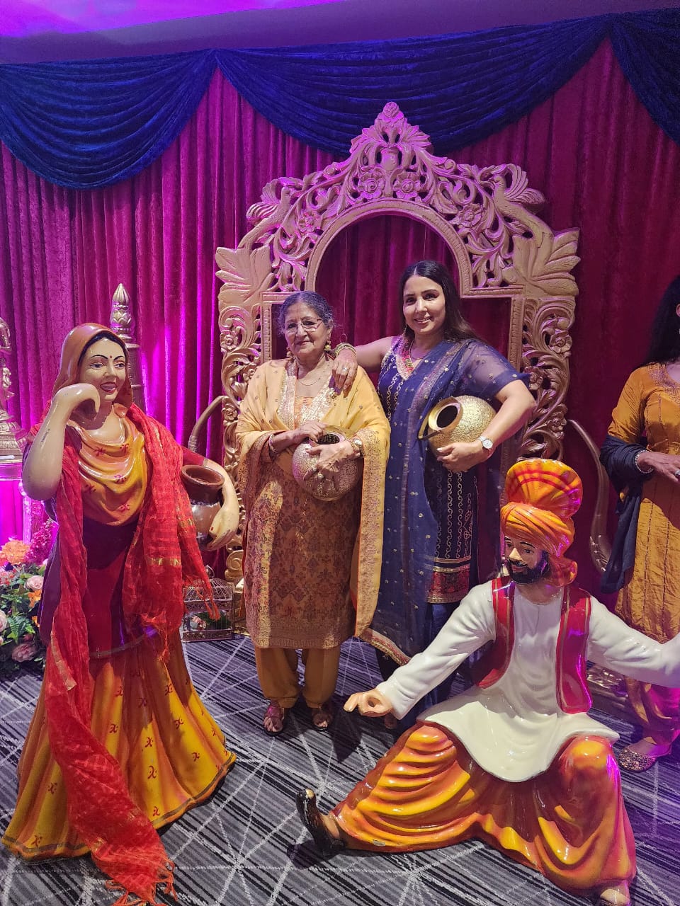 A warm moment at a Panjabi cultural event with folk sculptures
